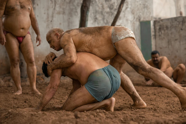 an image of men wrestling in the dirt