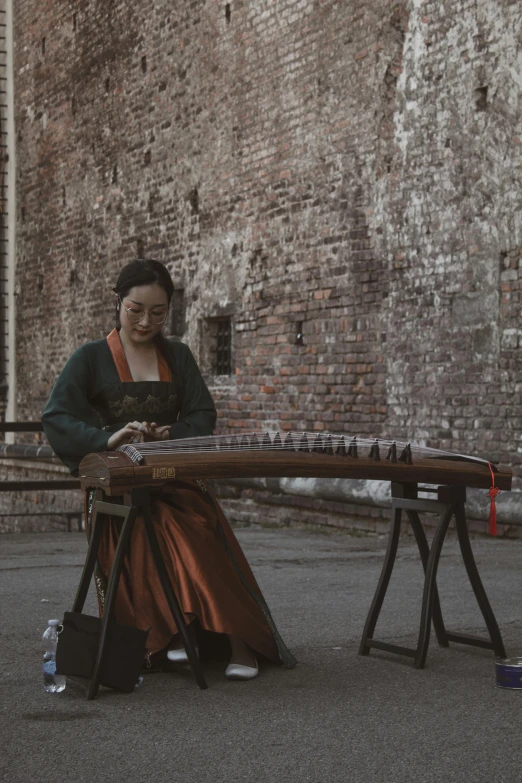 a woman in an elaborate dress plays a contraption