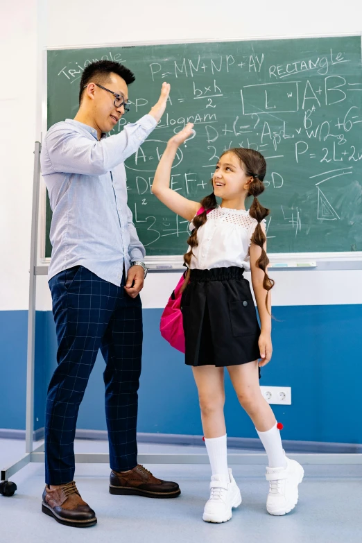 there is a teacher teaching a girl with her hand