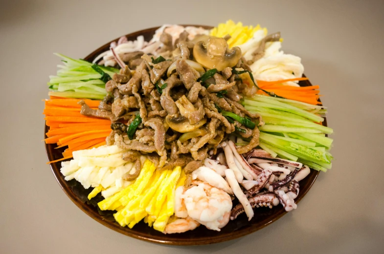 a plate with noodles, scallions, mushrooms, and other items