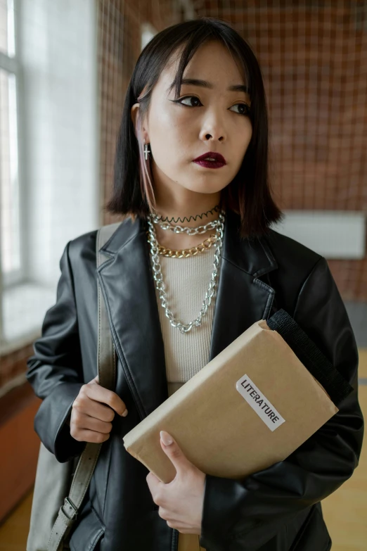 a woman is holding a brown folder while standing