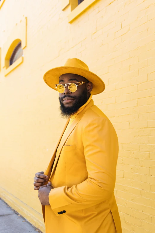 a man wearing a yellow suit and hat