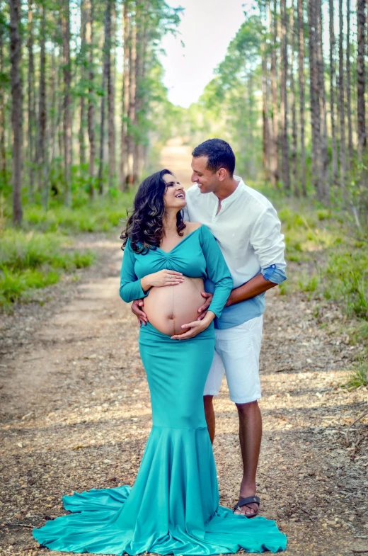 a pregnant couple is posing for a picture while their husband holds the belly