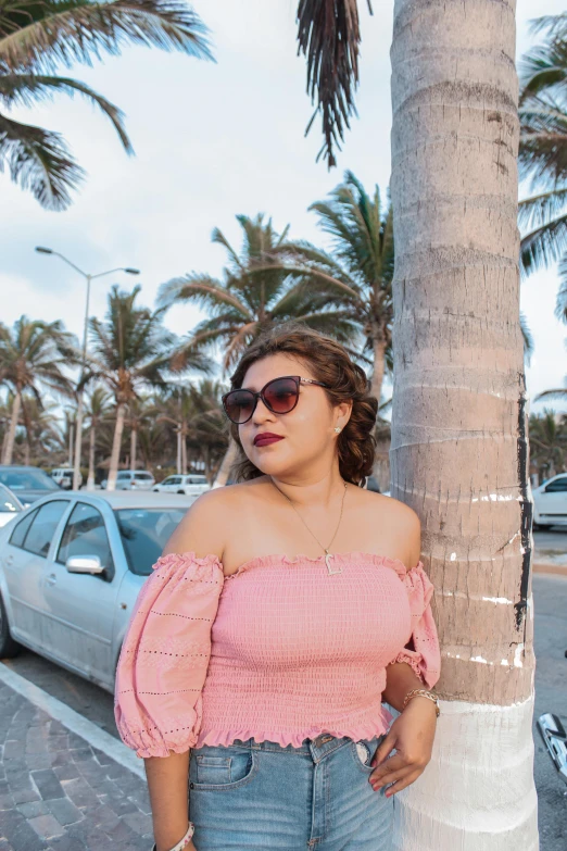 a young woman wearing blue jeans and a pink off the shoulder top