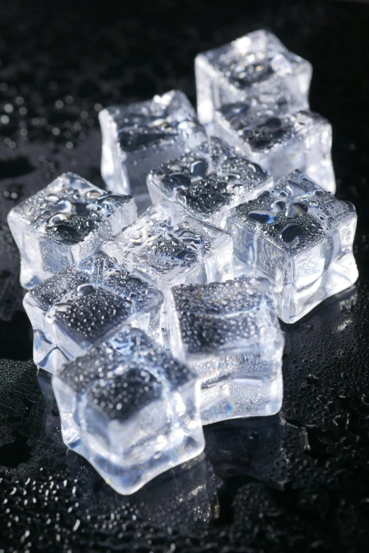 frozen cubes of ice lying on a black surface