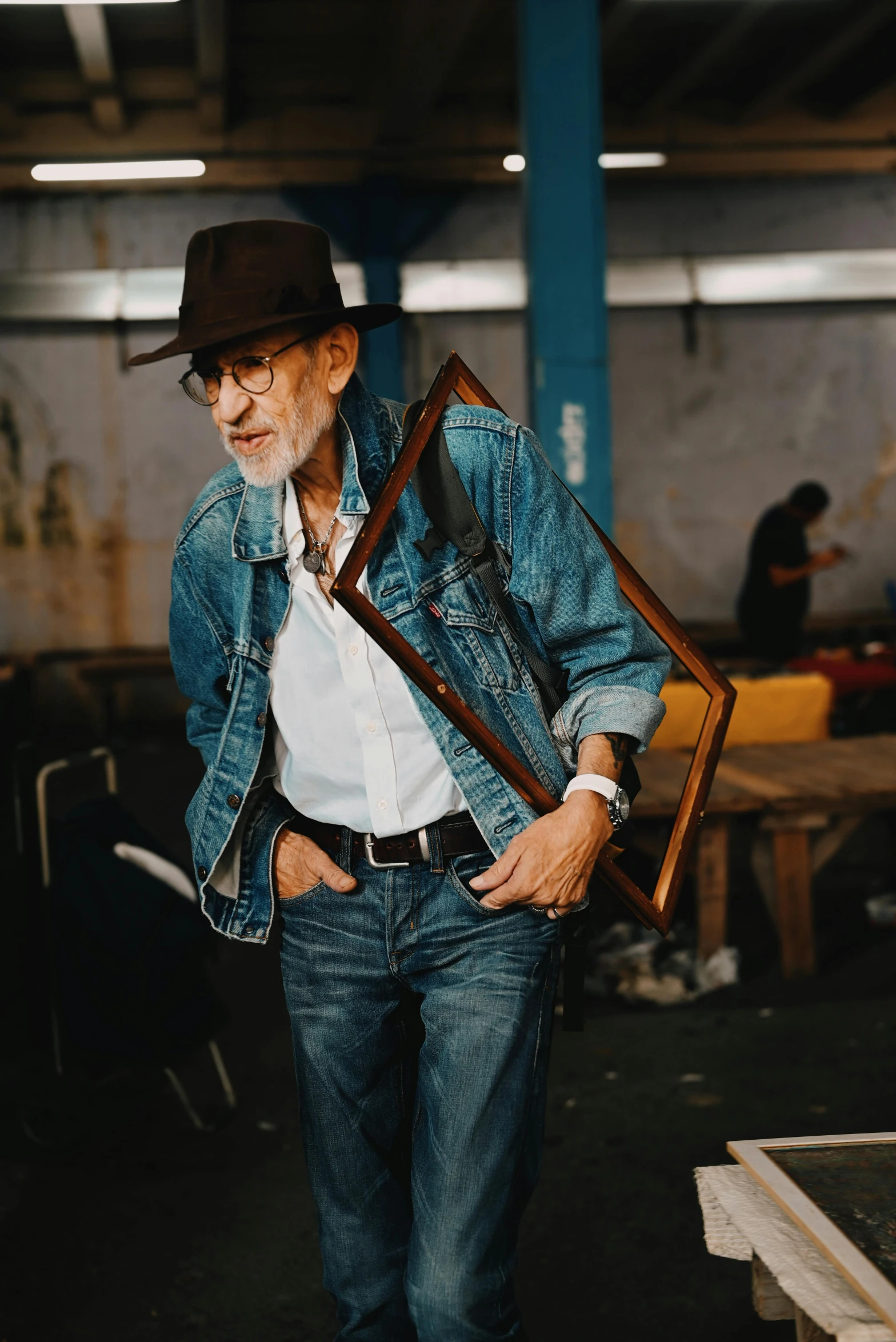 an older man holding a framed object in his hands