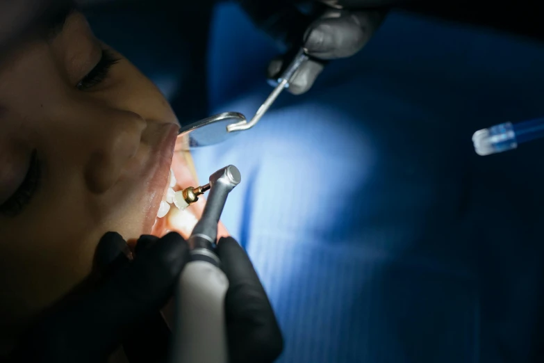 a dentist examining soing in the light of someone doing their teeth