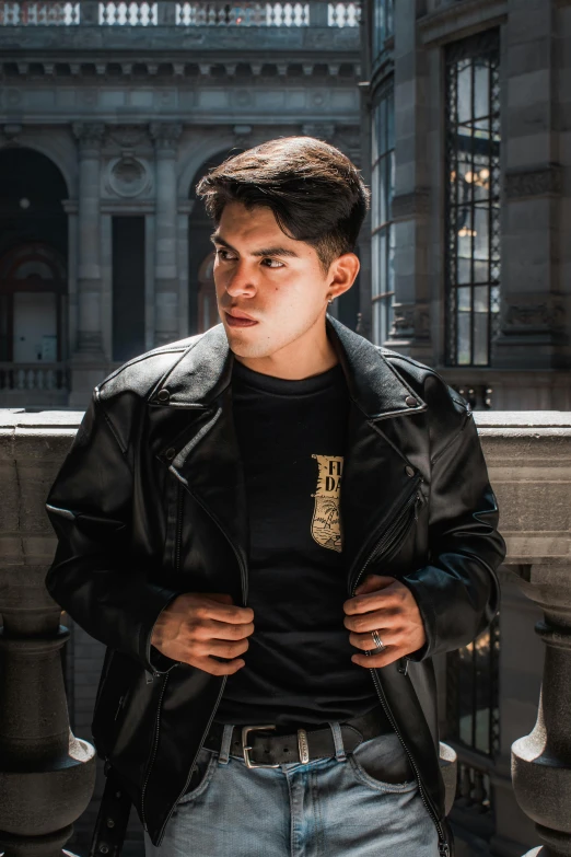 a young man with a hat and leather jacket on