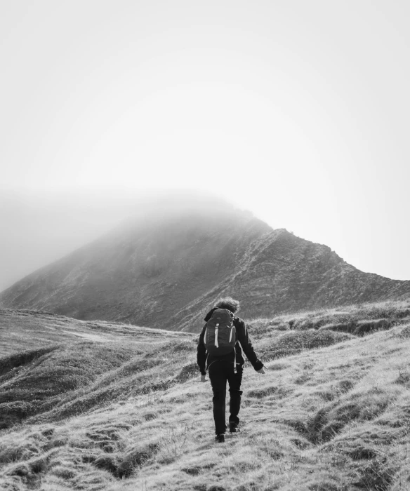 a person with a backpack walks down the hill