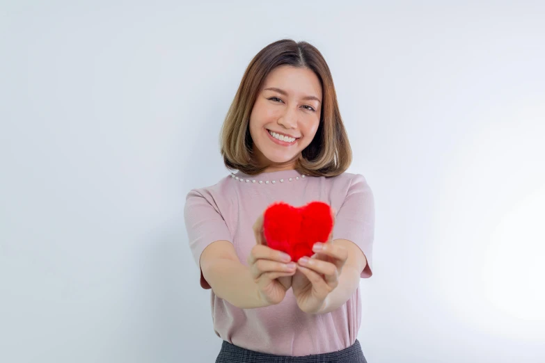 a woman holding a small heart in her hands