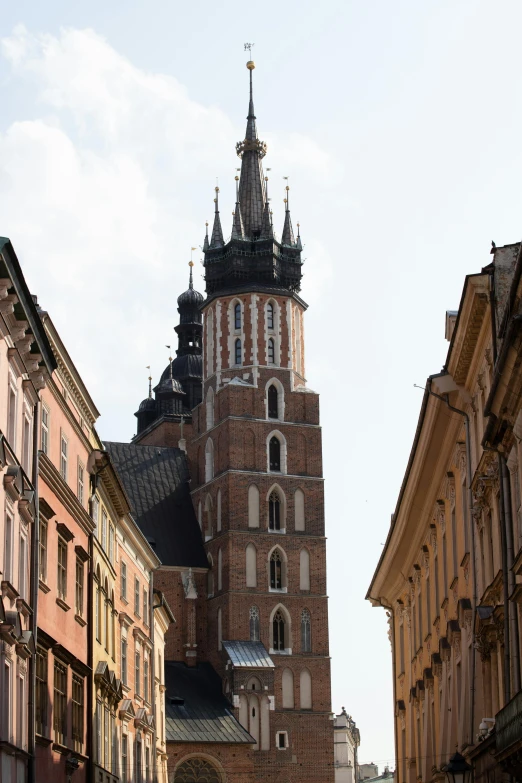 an old looking building with a spire stands behind other buildings