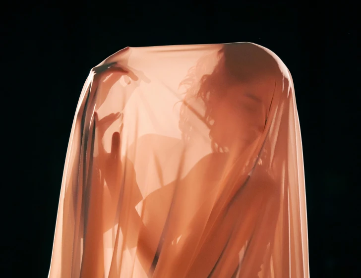 a woman is in a transparent cloth over her face