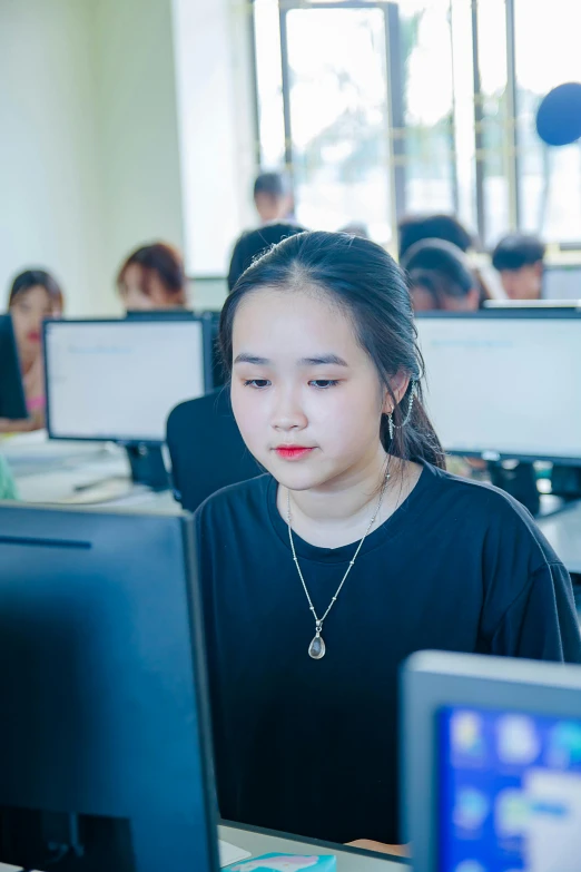 there is a girl at the computer with one ear hanging out