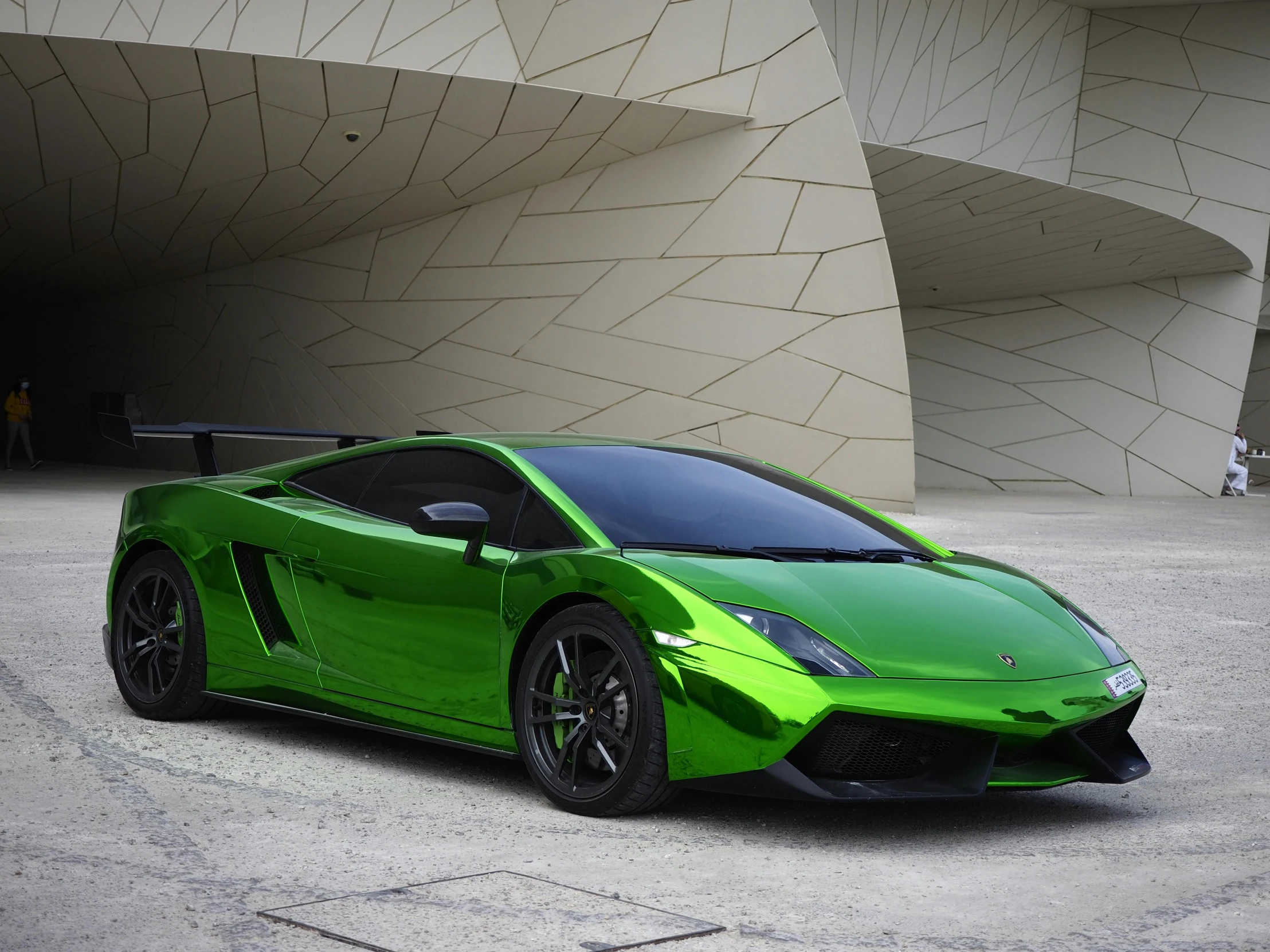 the green lamb car parked in front of a building