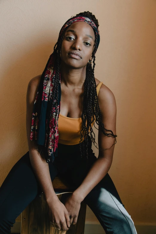 a woman sitting on a wooden surface posing for a po