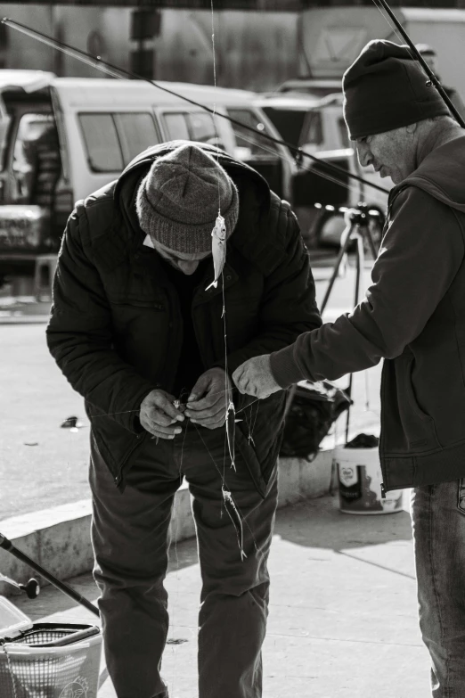 two men standing next to each other with fishing gear