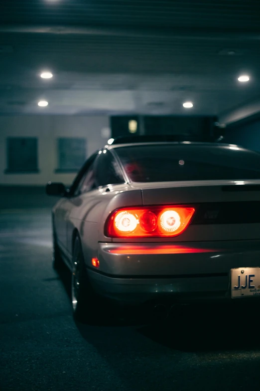 a black car parked in the middle of a parking lot at night