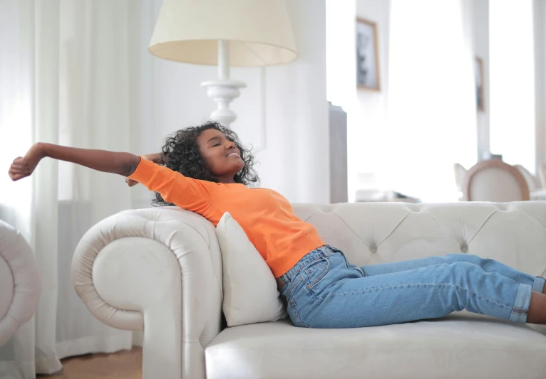 a black woman laying on top of a couch