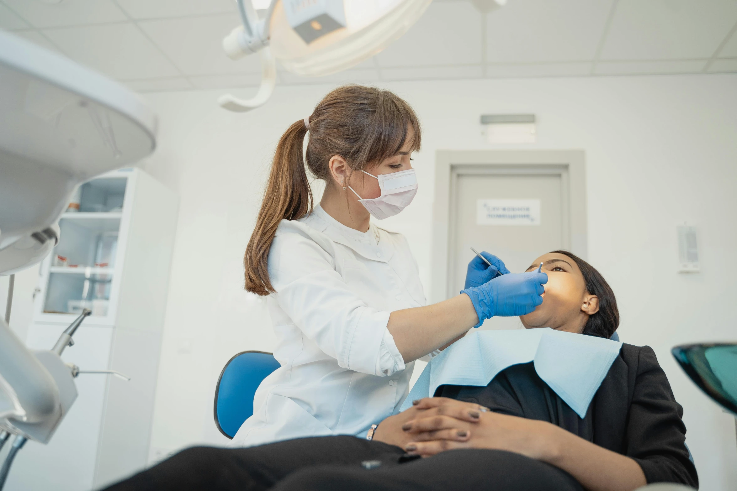 an older woman is undergoing dental treatment at a dentist