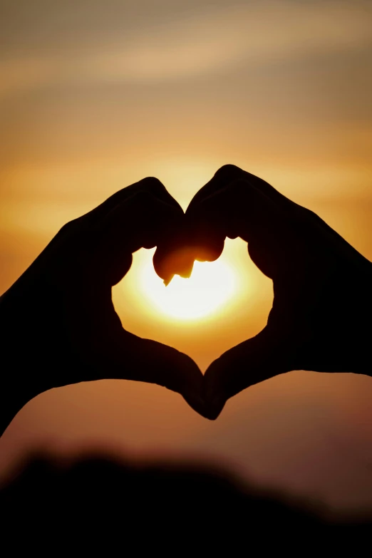 a person making a heart with their hands