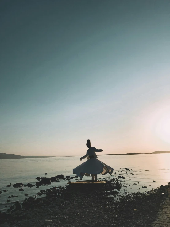 the woman is standing on a rock in the water