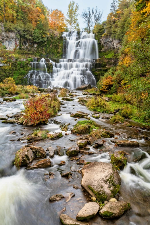 a waterfall flows down into a rocky river