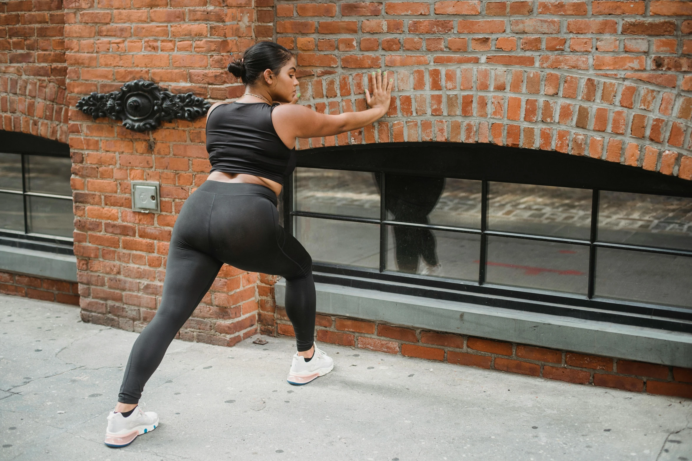 a woman in a black top is stretching her legs