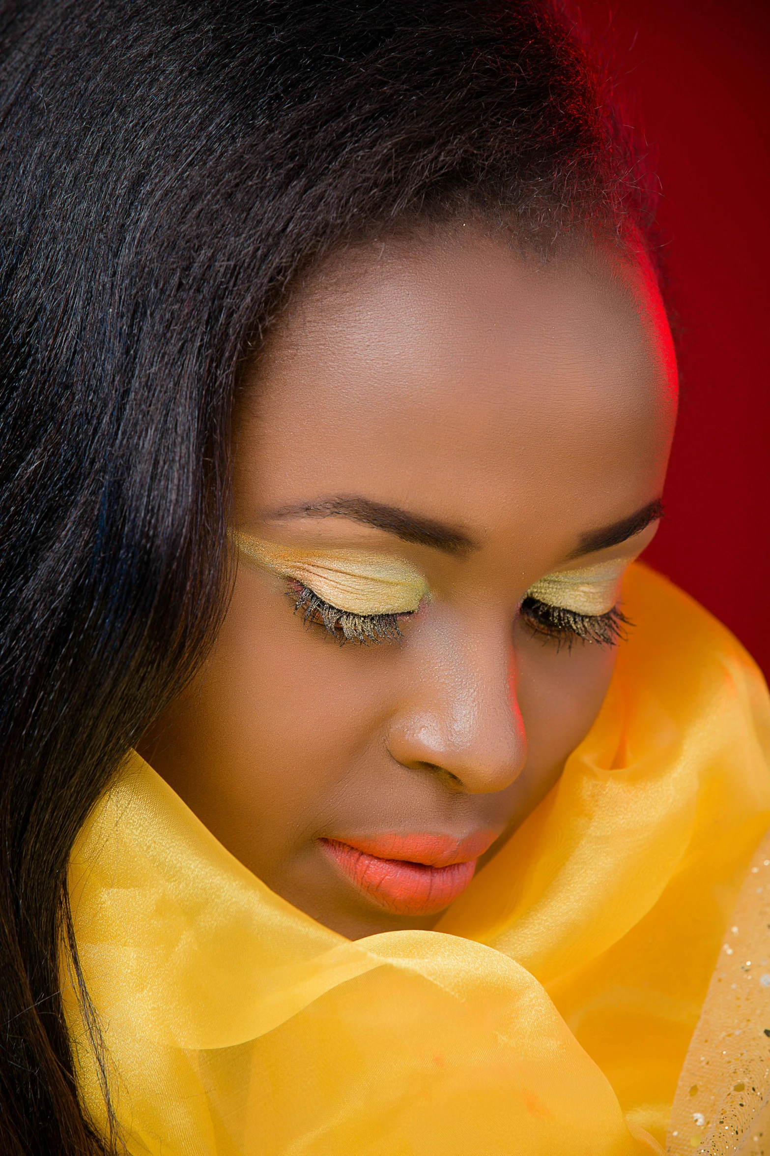 a woman wearing a yellow scarf with eyeliners on her face