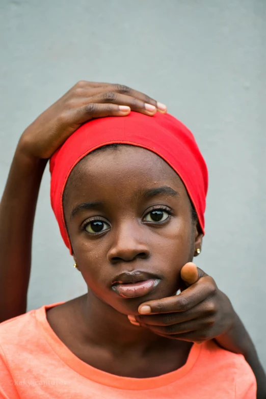 a girl wearing a red top and head scarf