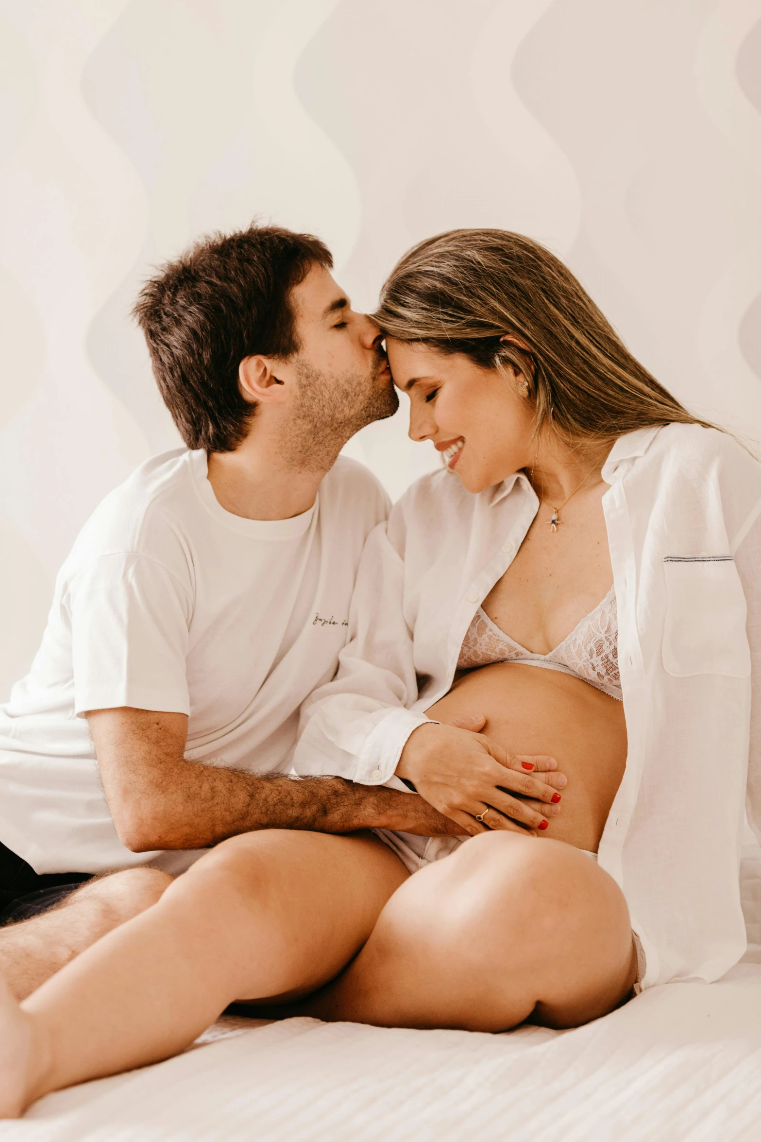 an image of a woman in lingerie and a man in shirt sitting on bed