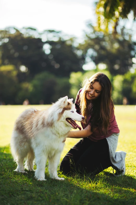 a woman pets a dog with her arm around it