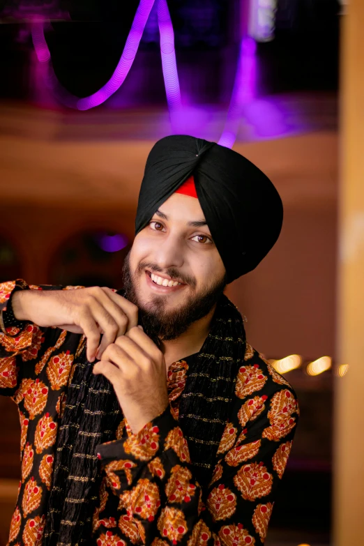 a man smiling at the camera in an indian suit