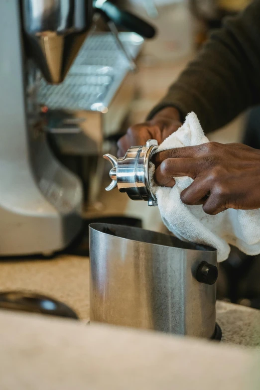 someone cleaning a metal trash can with a napkin