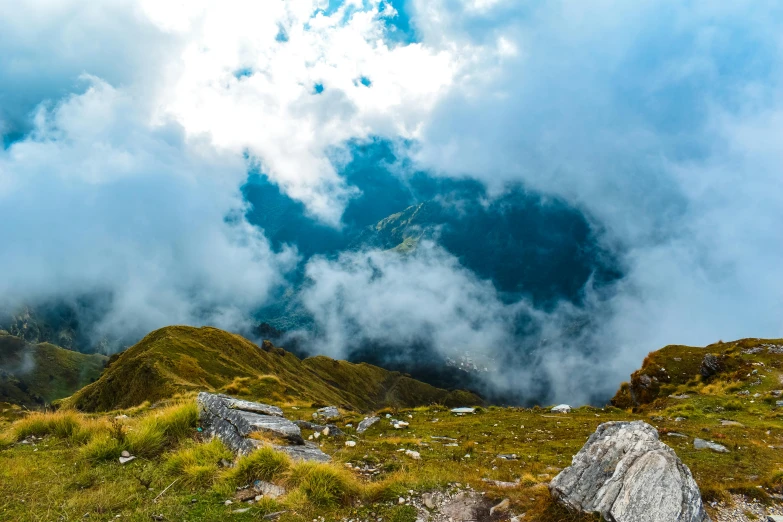 clouds moving through the sky over grass and rocks