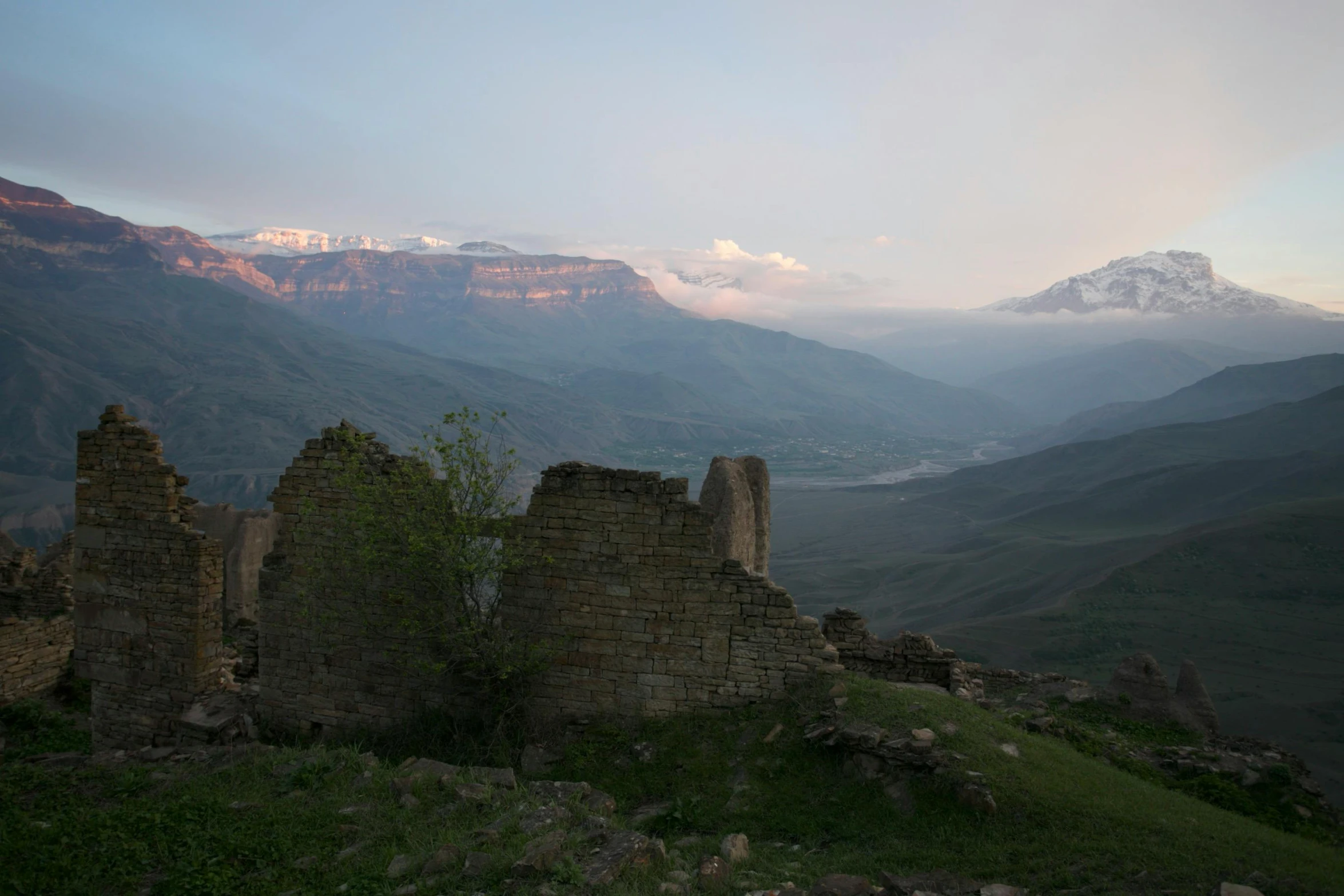 a rocky, old ruin surrounded by mountains