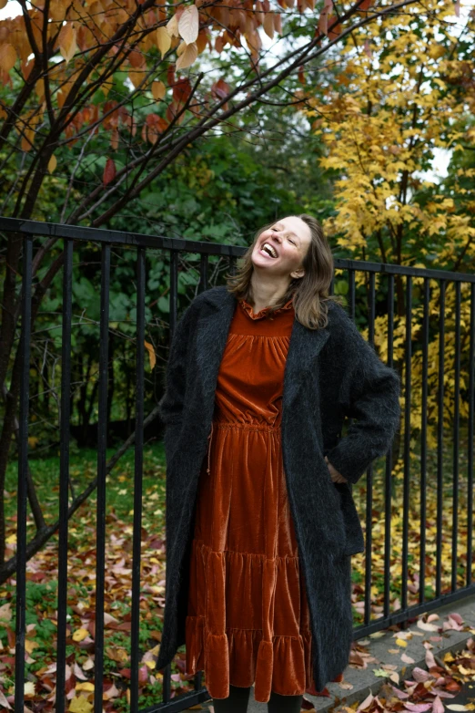 a woman standing by a fence looking up