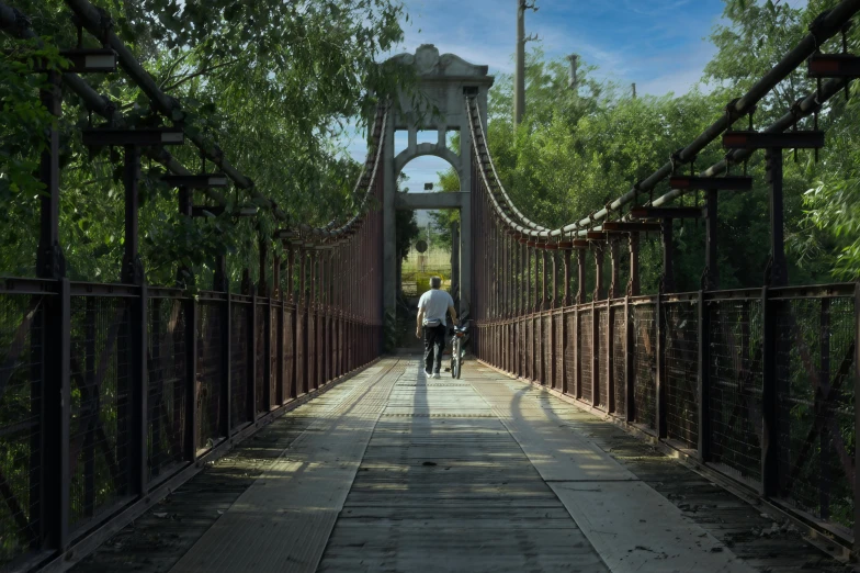 two people riding bikes on an old bridge