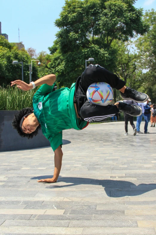 an athlete performing a hand stand with a ball