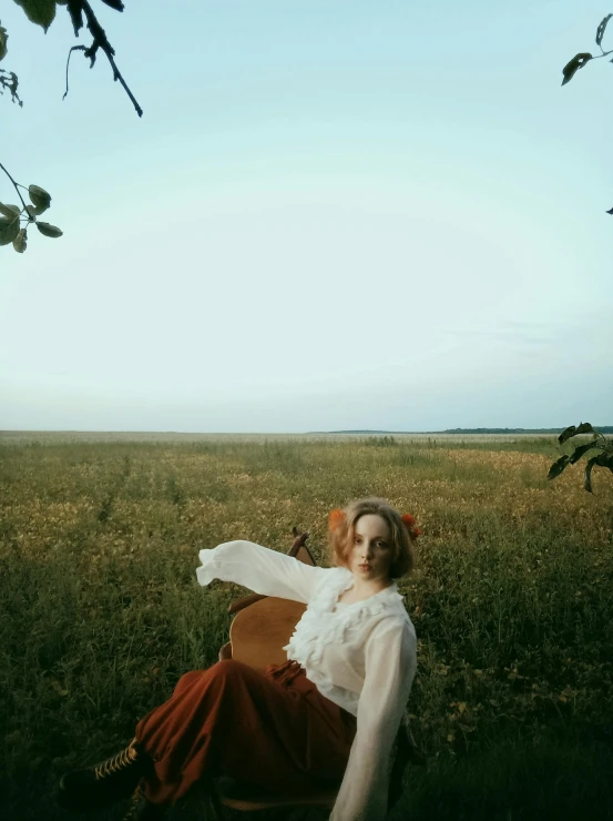 a woman sitting on a chair in the grass