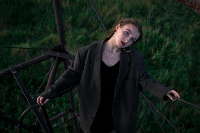 a girl standing on some steps in an overgrown field