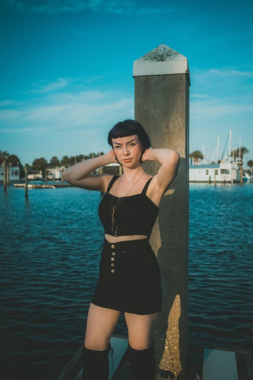 woman leaning against column posing at the water