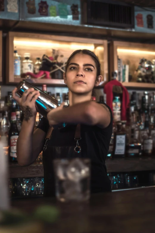 a woman bartender prepares a drink at the bar
