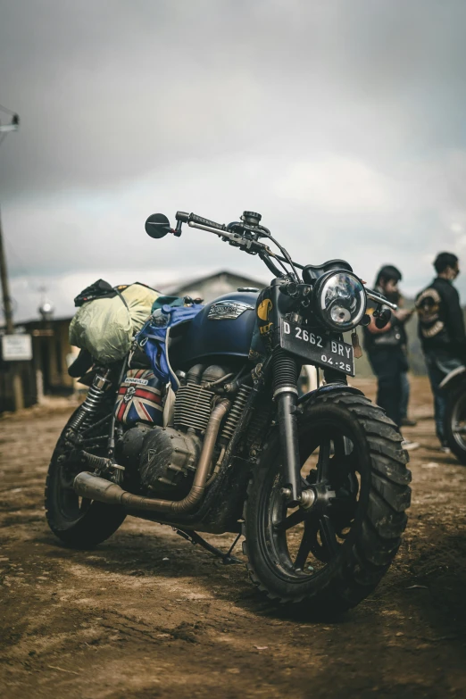 a motorcycle sitting in the mud with people on it