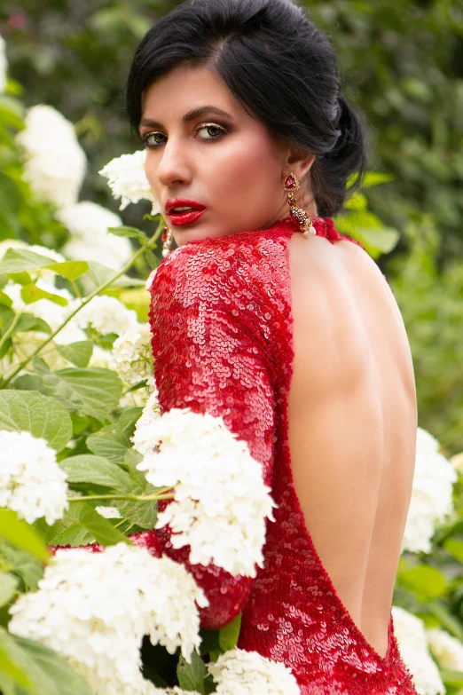 a woman posing for the camera in front of flowers