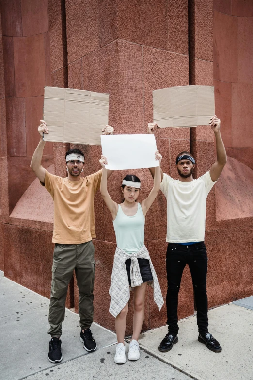 four young adults holding up signs that say no bullying