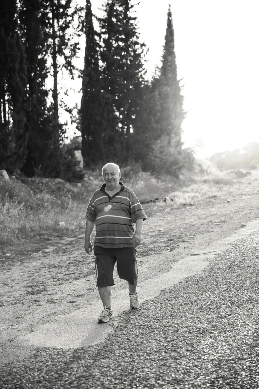 a man standing on the side of a dirt road