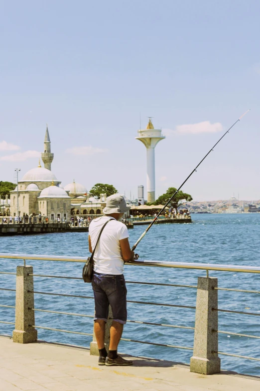 a man on the shore of a body of water while fishing