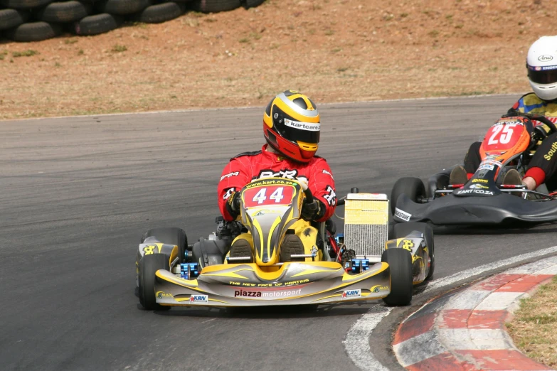 two people in go kart racing on a track