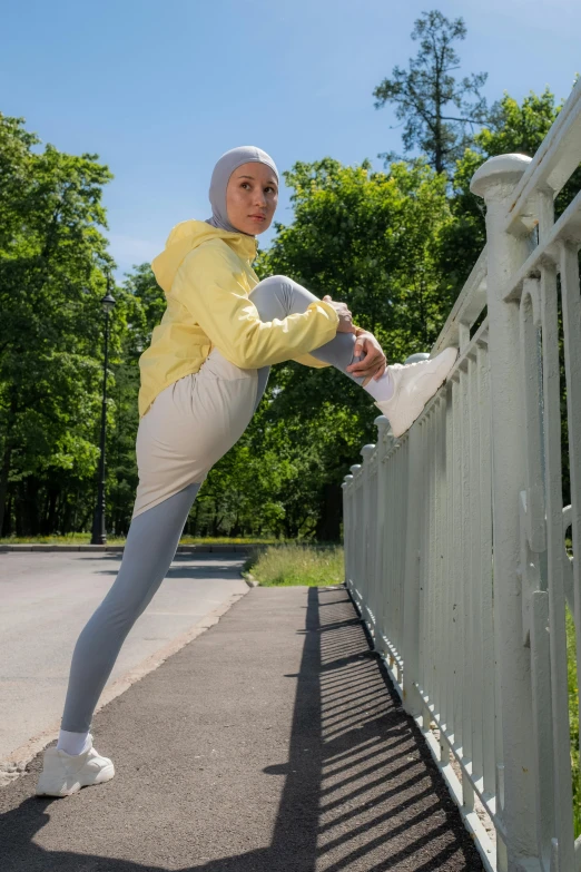 a woman is leaning over on a fence