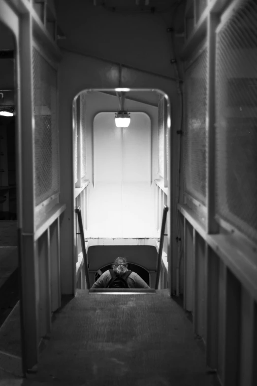 the hallway of a passenger jet with two windows and one man sleeping on the floor